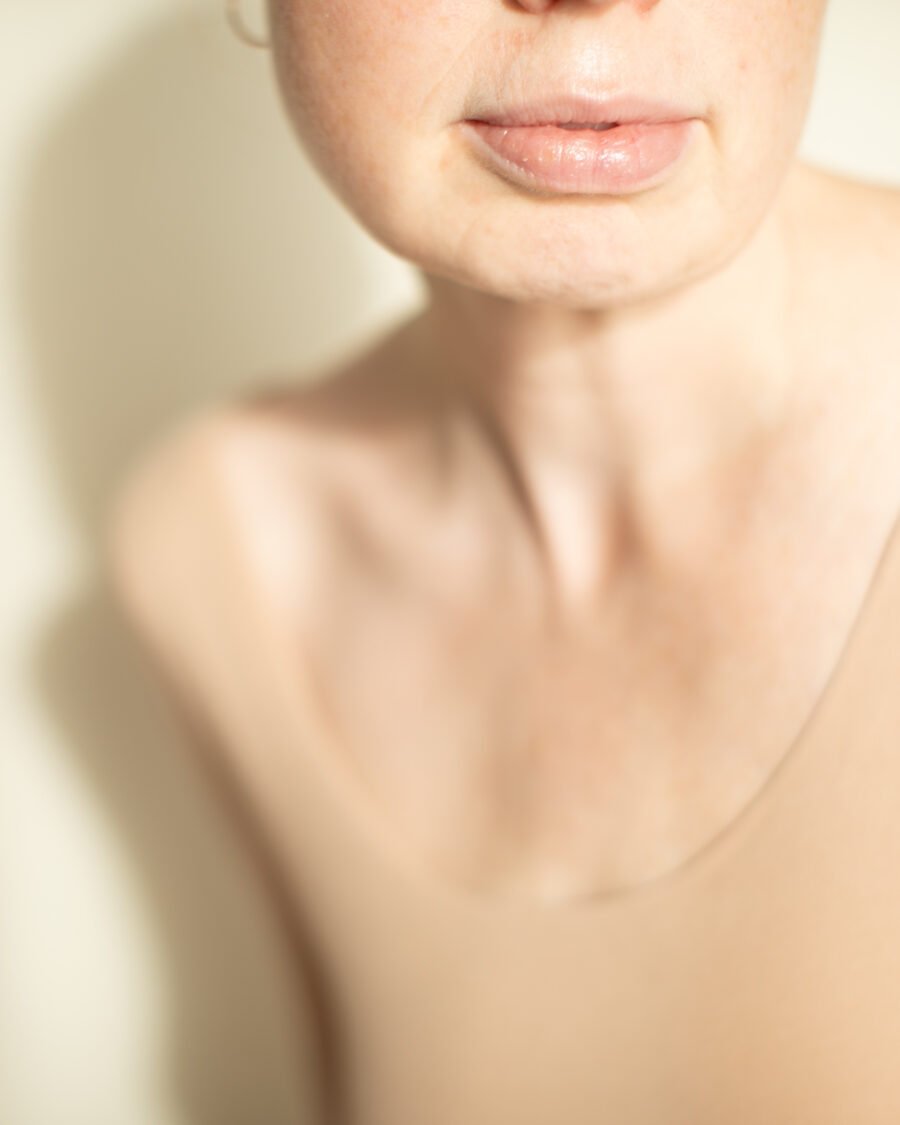 Close-up of lips and jaw in soft natural light, minimal skincare styling